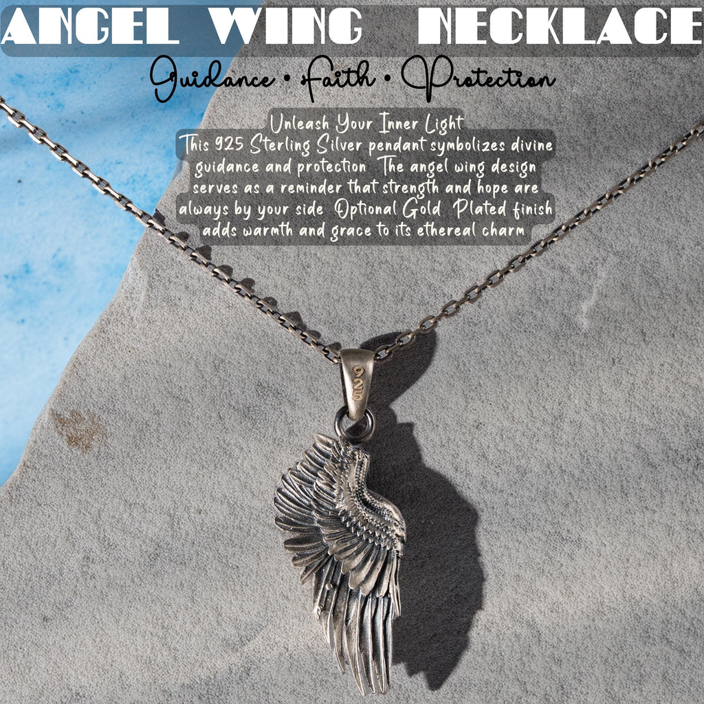 a silver angel wing pendant necklace with a chain, displayed against a gray rock background.